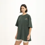 Remera marrón con estampado pequeño en el pecho que dice "We all grow" con una flor.