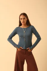 Remera de manga larga color azul, con cuello redondo y aberturas en los puños.