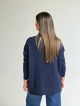 Sweater de punto en color azul marino, con escote en V, manga larga con puños acanalados y costura central vertical en el frente.