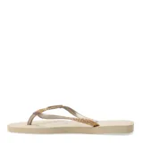 Sandalias tipo ojotas Havaianas modelo Slim Glitter II, color beige arena, con tiras finas cubiertas de glitter dorado.
