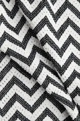 Pantalón de tiro alto confeccionado en punto jacquard con diseño de zigzag en blanco y negro. Presenta un corte de pierna amplia y cintura elástica.