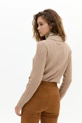 Sweater tipo polo color beige, tejido en ochos, con cuello clásico y media cartera de botones. Confeccionado en algodón y cashmere, de manga larga y terminaciones de rib.