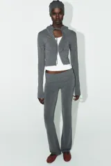 Sudadera cropped de punto con cierre frontal de cremallera metálica, capucha ajustable con cordones y mangas largas con puños en rib.