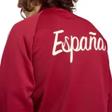 Campera deportiva Adidas de la selección de España, color bordó con las clásicas tres tiras blancas en las mangas, cuello alto y cierre frontal completo. Cuenta con bolsillos laterales y el escudo de la federación junto al logo de la marca bordados en el pecho.