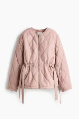 Campera acolchada de nylon guateado en color rosado, con cuello redondo, cierre frontal y cordón ajustable en la cintura con tiras colgantes. Presenta diseño acolchado con patrón de rombos, mangas largas y hombros caídos.