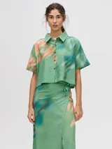 Falda midi tipo pareo color verde con estampado estilo tie-dye en tonos azul, naranja y blanco, con tiras ajustables en la cintura.