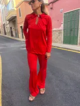 Conjunto de camisa y pantalón rojo con bordado de lunares. La camisa es de manga larga, con cuello polo y abertura en el pecho. El pantalón es de corte acampanado.