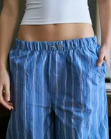Pantalón de poplin de algodón a rayas verticales celestes y blancas, con cintura elástica y bolsillos traseros.