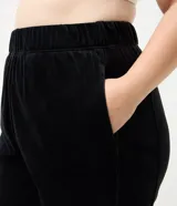 Pantalón jogger de plush color negro, con cintura elástica, bolsillos laterales y puños ajustados en los tobillos.