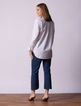 Camisa blanca de tencel, marca Grand & Greene, con cuello a la base, escote en V y abertura central con botones. Manga larga con puño y botón.