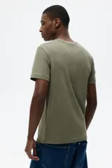 Remera de algodón liviano color verde militar, de corte slim fit con cuello redondo y mangas cortas.
