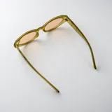 Lentes de sol con armazón carey de diseño ovalado, patillas anchas con detalle de pespuntes metálicos y cristales marrones degradados.