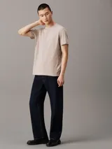 Remera de punto de algodón en color beige claro, con cuello redondo y corte regular. Presenta una cinta con logo en espiguilla de Calvin Klein en los laterales.