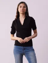 Buzo negro de tejido acanalado, marca Rio & Rian. Cuello solapa y escote en V en tejido calado.