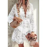 Vestido corto de encaje negro con diseño floral, escote en V profundo y mangas largas acampanadas. Presenta terminaciones con bordes festoneados.