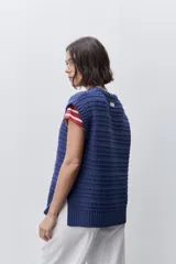 Chaleco tejido azul de calce relajado, silueta recta, cuello redondo, hombros caídos y diseño de punto con textura calada.