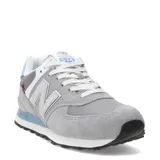 Championes urbanos New Balance modelo 574, color gris con detalles en celeste y blanco. Confeccionados en una combinación de gamuza y material sintético, presentan el logo N en los laterales y entresuela con tecnología ENCAP.