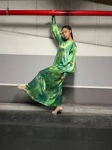 Vestido largo verde con estampado abstracto en tonos amarillos, de corte holgado y mangas largas con puños elásticos.