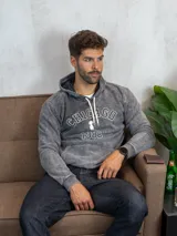 Hoodie de algodón con efecto lavado, color gris, con capucha y cordones ajustables. Presenta un estampado frontal con la inscripción 'CHICAGO' y '1982' junto a un pequeño gráfico central.