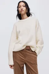 Buzo de punto suave con diseño oversized, cuello redondo acanalado, hombros caídos y terminaciones acanaladas en puños y bajo.