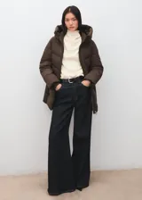Parka acolchada color marrón chocolate, con diseño puffer, capucha integrada, cierre frontal y bolsillos laterales.