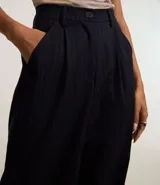 Pantalón pantalona de sastrería con rayas verticales, trabillas en la cintura y cierre con botón y cremallera. Confeccionado en poliéster, viscosa y elastano.