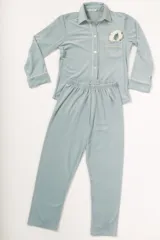 Pijama celeste de terciopelo, compuesto por una camisa de manga larga con botones y vivo blanco, bolsillo en el pecho y un pantalón recto con elástico en la cintura.