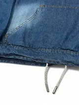 Canguro con capucha de denim azul, con efecto desgastado en el centro del pecho. Presenta un bolsillo canguro frontal y cordones ajustables en el bajo para modificar el calce.