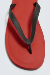 Sandalia de goma con suela plana roja y tiras negras en el empeine, parte de la colección especial Aaron Levine x Zara.