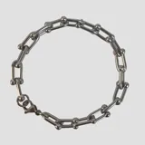 Pulsera de eslabones alargados de acero con cierre de mosquetón.