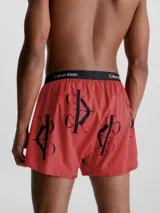 Boxer de algodón con estampado repetido del logo 'CK' en negro sobre fondo rojo. Cintura elástica negra con el logo 'Calvin Klein' en blanco.