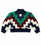 Sweater de cuello alto tejido con diseño geométrico en zigzag multicolor, incluyendo tonos azul marino, verde, bordó y crema. Presenta puños y ruedo acanalados.