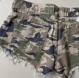 Short de denim con estampado camuflado, tiro medio, bolsillos clásicos y terminación desmechada en las piernas.
