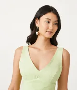 Enterito corto color verde claro, con escote en V, tirantes anchos y detalle de ondas en el frente.