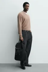Mochila de cuero con acabado de serraje, cuenta con un compartimento principal con cierre de solapa y cordón ajustable. Incluye asa de mano superior y correas de hombro ajustables.