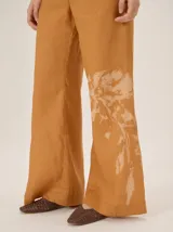 Pantalón de lino color azul metalizado, de corte sastrero, tiro medio y pierna recta amplia.