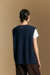 Chaleco tejido de punto en color azul marino, con diseño de textura sutil en relieve, escote redondo y terminaciones acanaladas en cuello, sisas y ruedo.