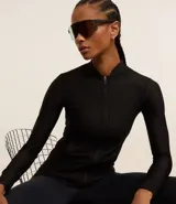 Campera deportiva negra de microfibra con textura, cuello padre, cierre por cremallera, bolsillos y detalle de dedito en los puños.