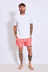 Short de baño color salmón con estampado de pequeños motivos, cintura elástica con cordón ajustable y corte recto.