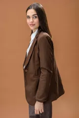 Blazer de corte clásico y estructurado en color marrón con textura de espiga. Presenta solapas tradicionales, cierre frontal y mangas largas.