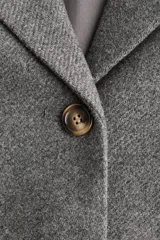 Blazer de botonadura sencilla en mezcla de lana color gris. Modelo con solapas de muesca, hombreras y bolsillos de parche delanteros. Cuenta con cierre de botones en el frente y forro interior.