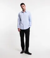 Camisa de vestir blanca de algodón con textura maquinetada, cuello camisero y mangas largas.