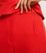 Pantalón de sastrería corte wide leg, de tiro alto con cintura doble y detalle de remaches metálicos en la parte frontal.