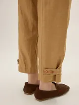 Pantalón de lino y poliéster color blanco, de corte holgado estilo barrel con costuras decorativas y bolsillos laterales.