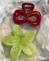 Set de dos clips para el pelo: uno azul con lunares rojos y otro rojo con forma de moño.