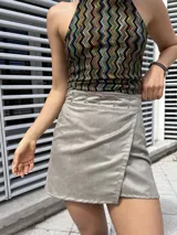 Minifalda gris cruzada de gamuza sintética, con hilera de ojales metálicos en la cintura.