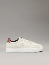 Zapatillas de corte bajo Calvin Klein Jeans en color beige, confeccionadas en una combinación de ante y piel nobuck. Presentan un diseño minimalista con suela cupsole blanca, detalle de trabilla trasera en color marrón y forro interior en contraste negro. Incluye el logo de la marca grabado en el lateral y en la mediasuela.