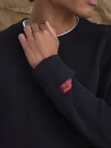 Buzo de cuello redondo confeccionado en tejido fleece, de corte clásico y manga larga, con puños y ruedo acanalados.