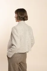 Chaqueta de sastrería color crema, entallada y con cuello erguido. Prenda forrada de lana fina sin teñir.