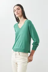 Sweater verde de tejido de punto, con escote en V y mangas largas.